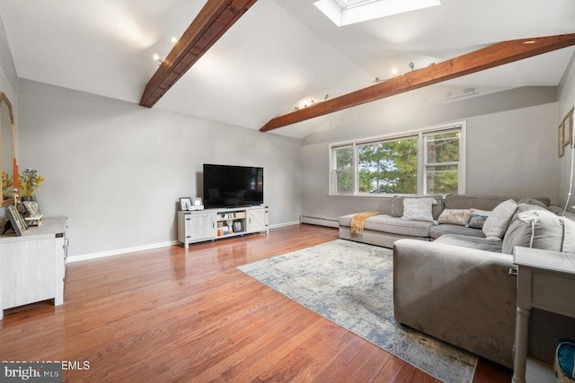 living room with lofted ceiling with skylight, hardwood / wood-style floors, and baseboard heating