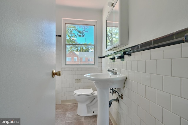 bathroom featuring tile walls and toilet