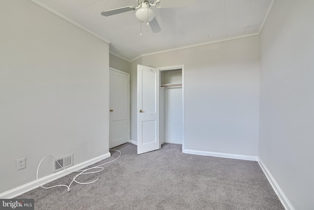 unfurnished bedroom with ceiling fan, a closet, light carpet, and crown molding