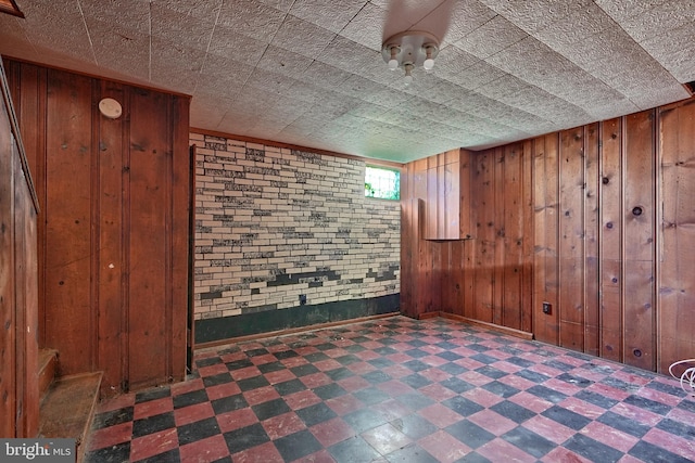 basement with brick wall and wood walls