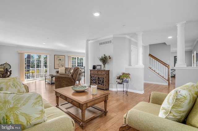 living room featuring ornamental molding, light hardwood / wood-style flooring, and decorative columns