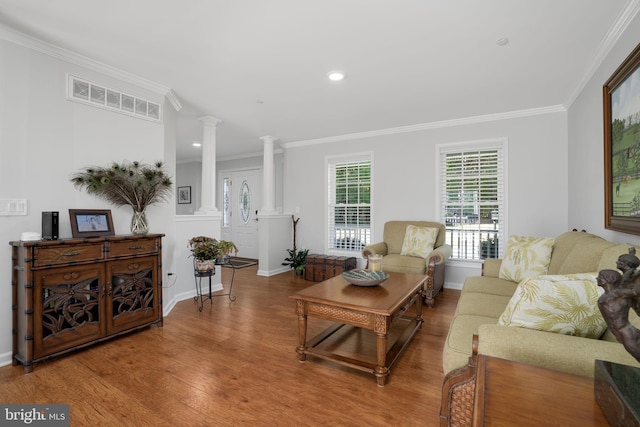 living room featuring wood-type flooring, ornamental molding, and decorative columns