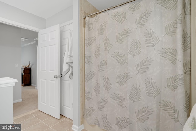 bathroom with curtained shower and tile patterned floors