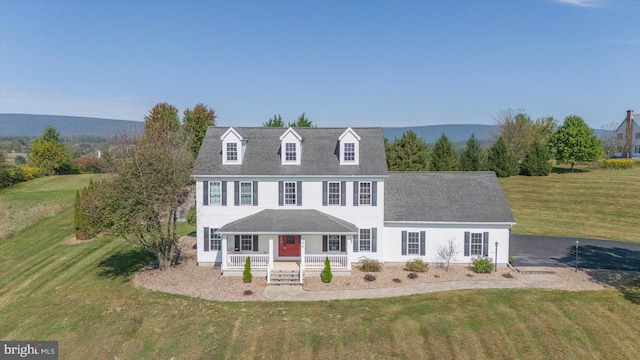 view of front of home featuring a front lawn, a mountain view, and covered porch