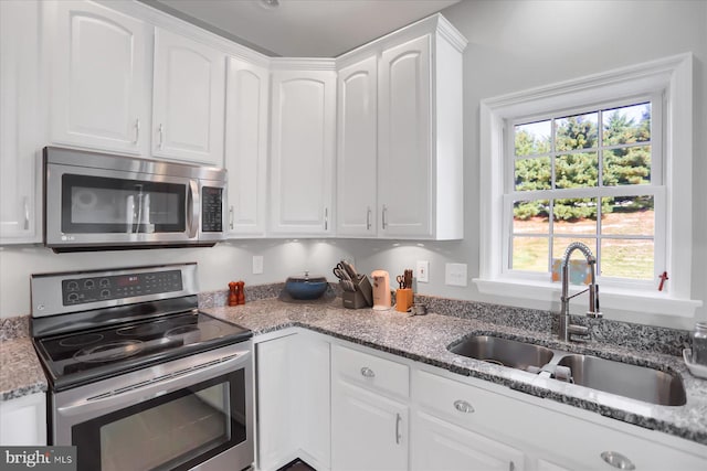 kitchen featuring stainless steel appliances, plenty of natural light, and white cabinets