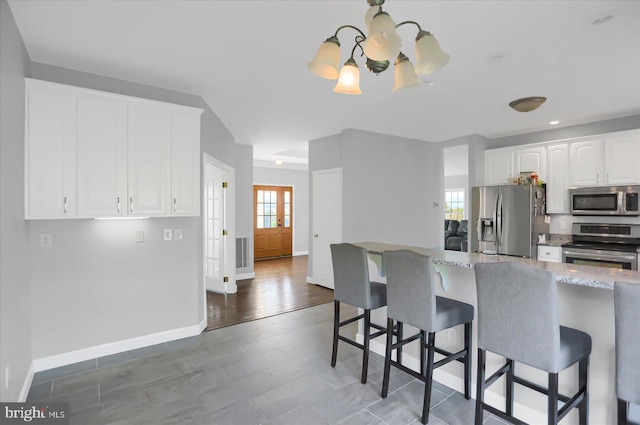 kitchen featuring stainless steel appliances, plenty of natural light, white cabinets, and dark wood-type flooring