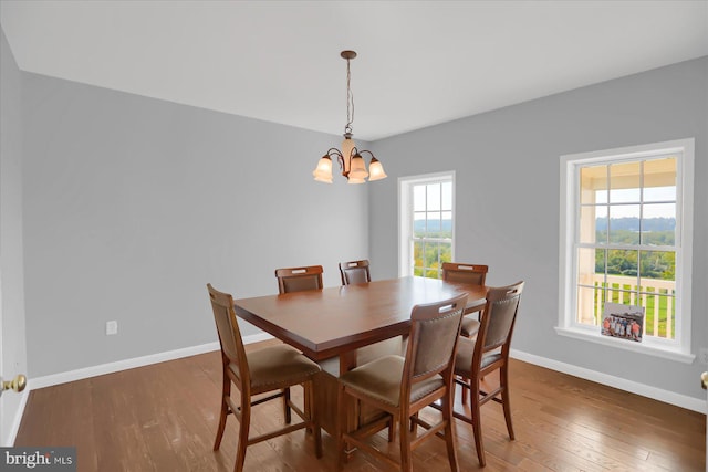 dining space featuring a notable chandelier, dark hardwood / wood-style flooring, and a healthy amount of sunlight