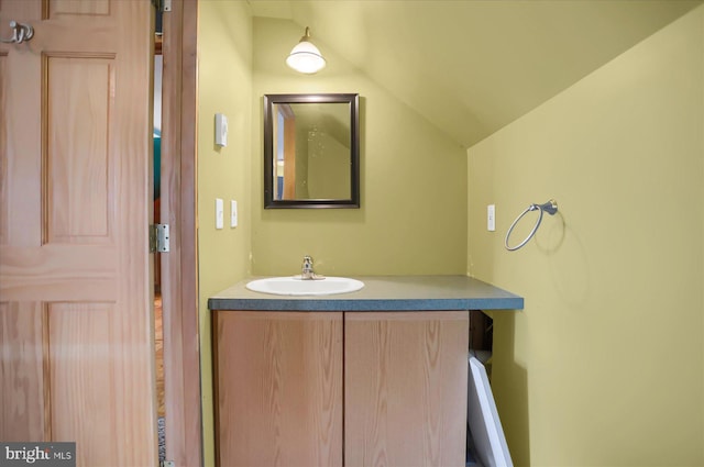 bathroom with lofted ceiling and vanity