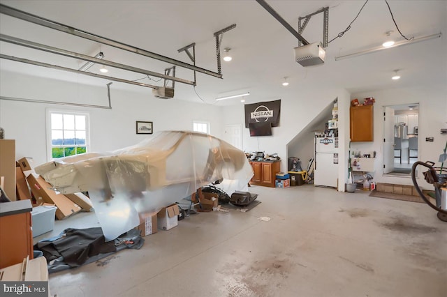 garage featuring a garage door opener and white refrigerator