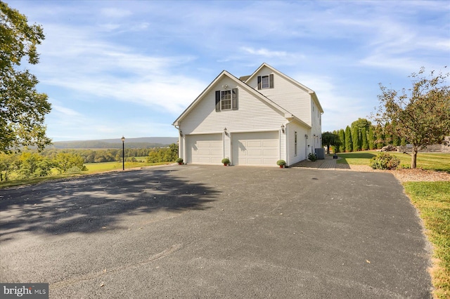 view of home's exterior featuring central air condition unit and a garage