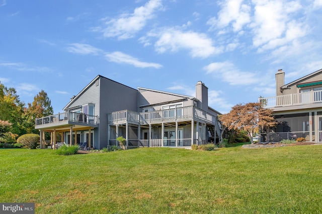 rear view of house featuring a balcony and a lawn