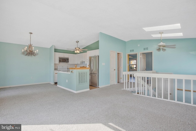 interior space featuring lofted ceiling with skylight, light carpet, and an inviting chandelier