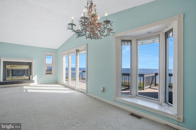 unfurnished living room with a water view, carpet, and plenty of natural light