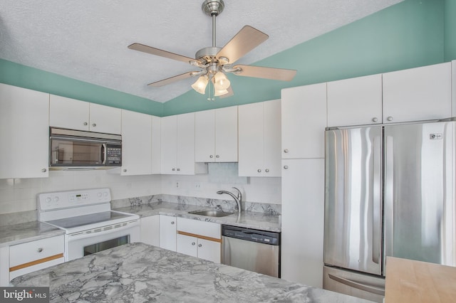 kitchen with sink, vaulted ceiling, appliances with stainless steel finishes, and white cabinets