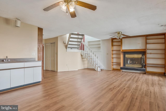 unfurnished living room with a textured ceiling and light wood-type flooring