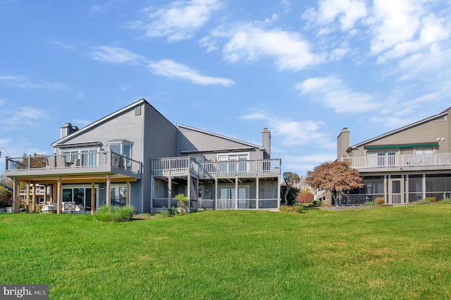 back of house featuring a wooden deck and a lawn