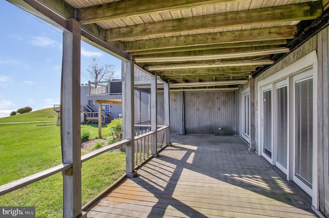 wooden terrace featuring a lawn