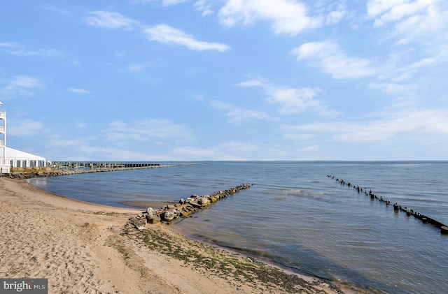 dock area with a water view and a beach view