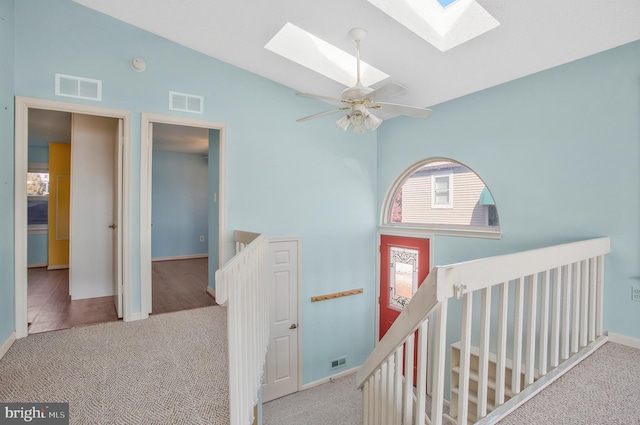 hall with light carpet and lofted ceiling with skylight