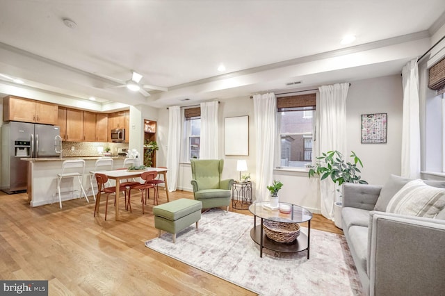 living room with light wood-type flooring and ceiling fan