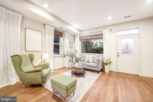 living room featuring light hardwood / wood-style flooring and crown molding