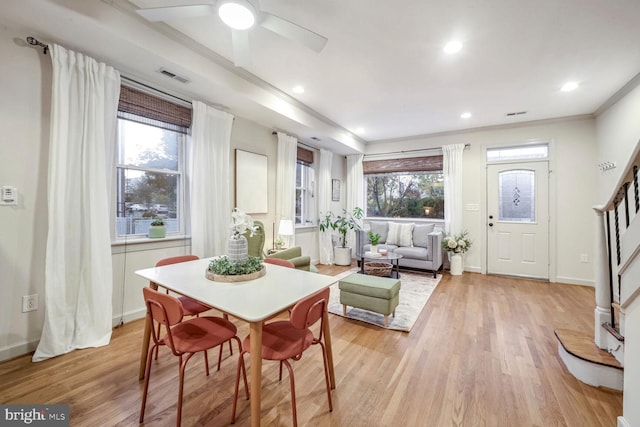 dining room with crown molding, light wood-type flooring, a healthy amount of sunlight, and ceiling fan