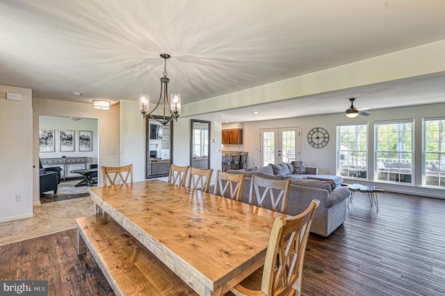 dining room featuring french doors, wood-type flooring, and ceiling fan with notable chandelier