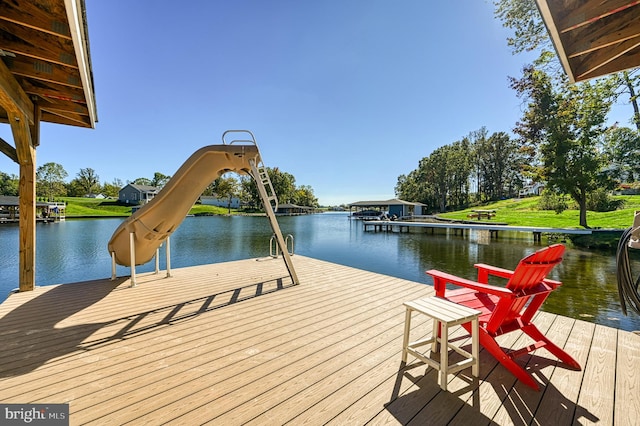 dock area with a lawn and a water view