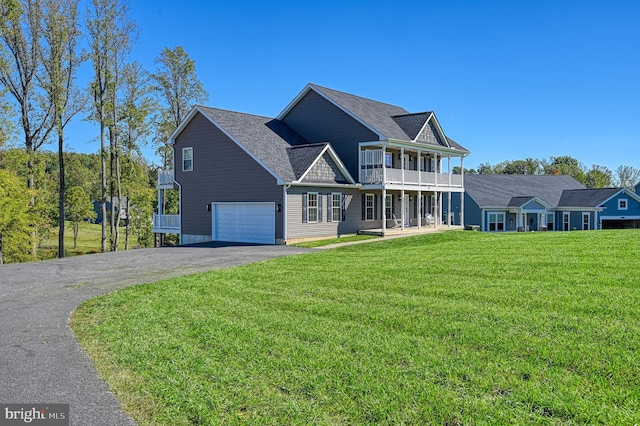 view of front of home featuring a front lawn, a garage, and a balcony