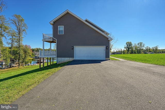 view of side of home with a balcony, a water view, a garage, and a lawn