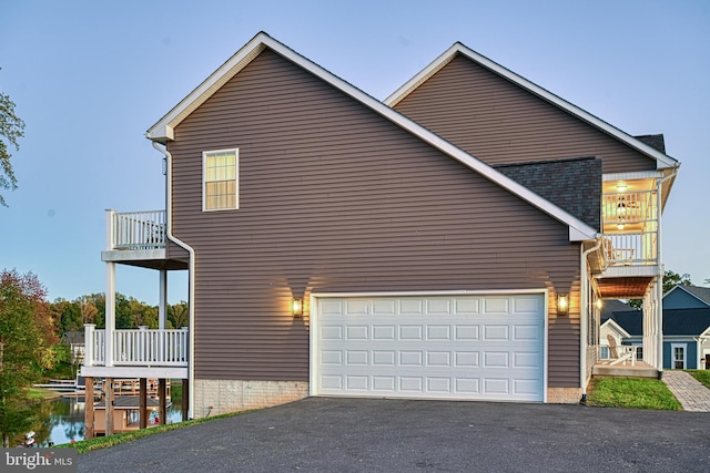 view of side of property featuring a garage and a balcony