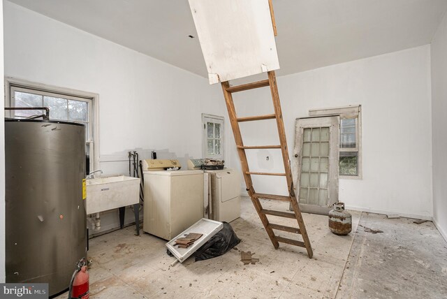 laundry room with water heater, sink, and independent washer and dryer