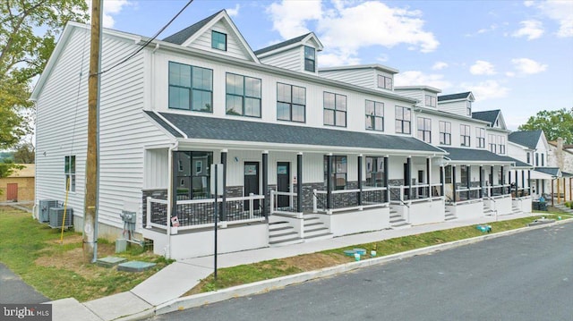 view of property featuring central air condition unit and covered porch