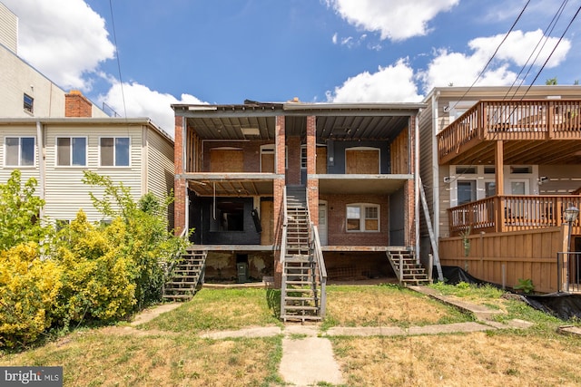 back of house with a deck and a yard