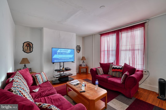 living room featuring baseboards and hardwood / wood-style flooring