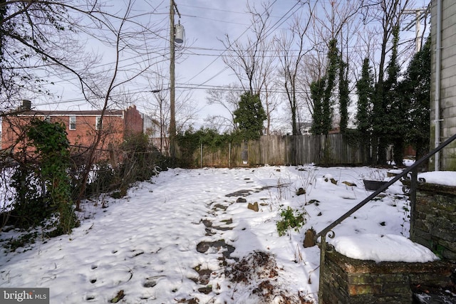 yard layered in snow with fence
