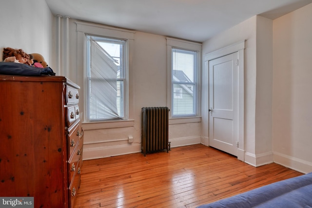 interior space with light wood-style flooring, radiator heating unit, and baseboards