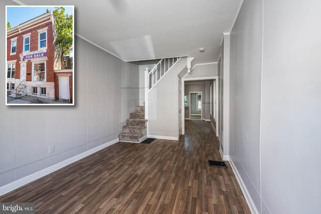 unfurnished living room featuring dark hardwood / wood-style floors and crown molding