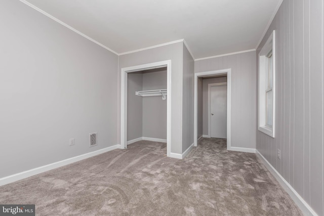 unfurnished bedroom with light colored carpet, a closet, and crown molding