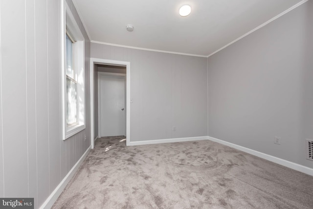 spare room with crown molding and light carpet