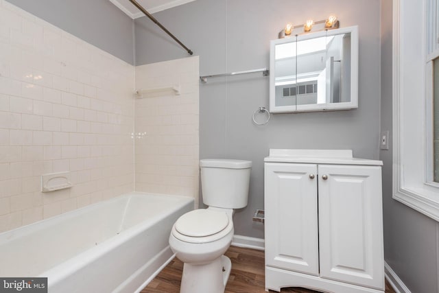 full bathroom with washtub / shower combination, crown molding, toilet, vanity, and hardwood / wood-style flooring