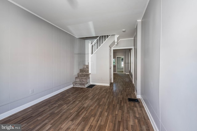 unfurnished living room with dark hardwood / wood-style floors and crown molding