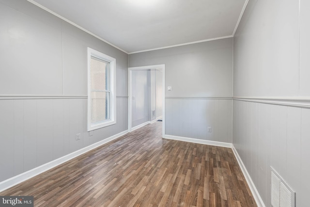 spare room with a healthy amount of sunlight, crown molding, and dark wood-type flooring