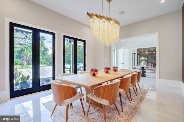 dining area featuring french doors and a notable chandelier