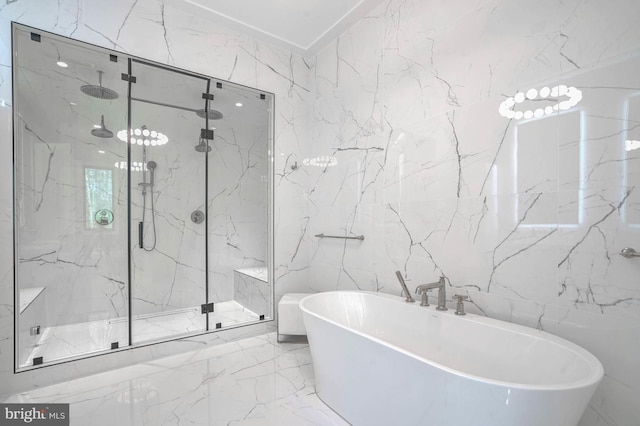 bathroom featuring tile walls, marble finish floor, a marble finish shower, and a freestanding bath
