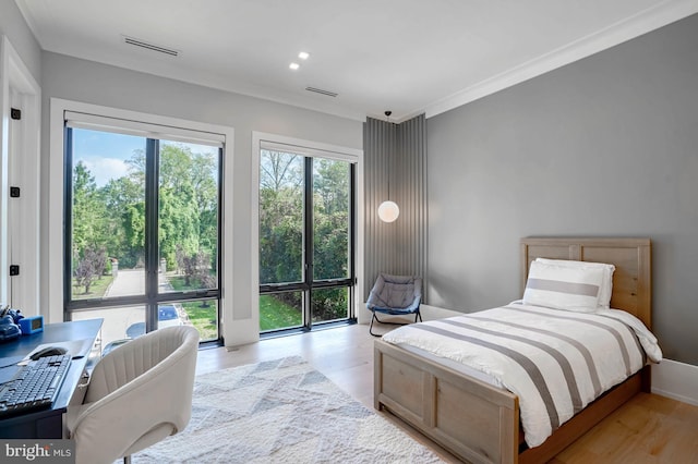 bedroom with light hardwood / wood-style floors and crown molding