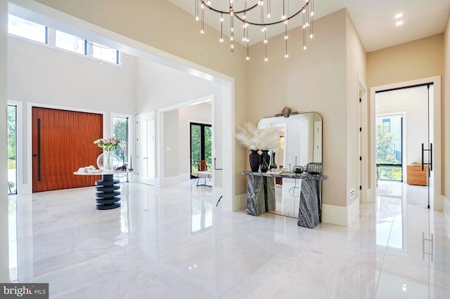 entryway with a high ceiling and a chandelier