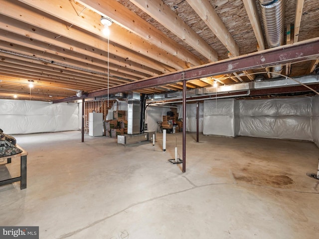 basement with white fridge and heating unit