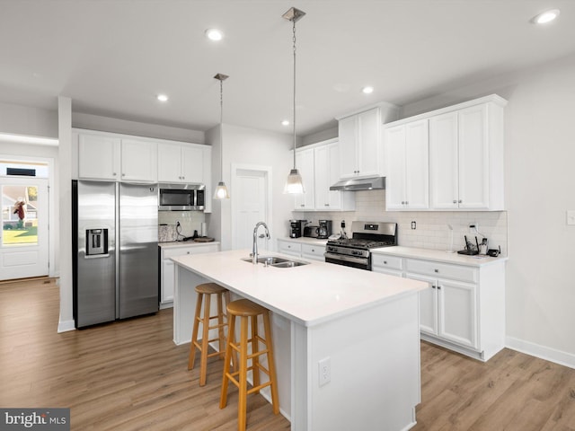 kitchen featuring light hardwood / wood-style floors, appliances with stainless steel finishes, sink, and white cabinetry