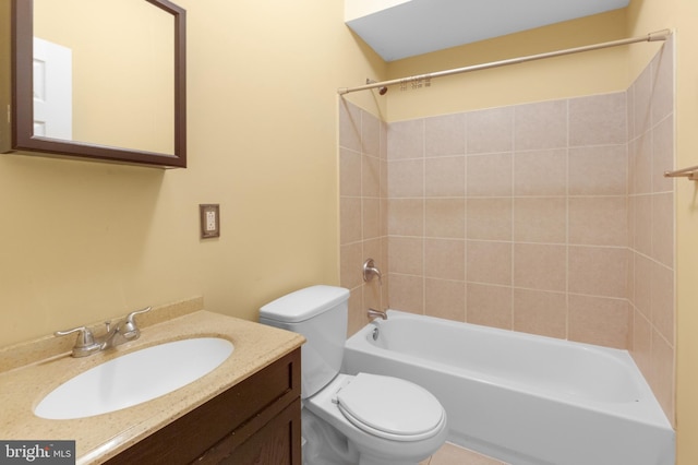 full bathroom featuring toilet, tiled shower / bath combo, and vanity